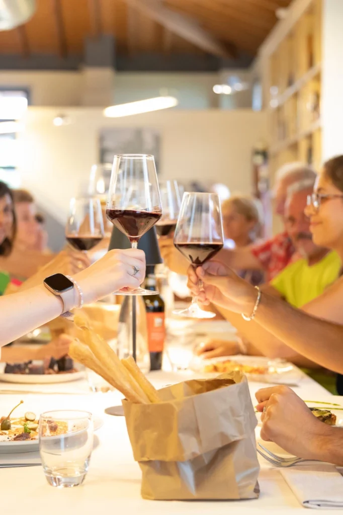 Una tavola di gente che sta brindando, sullo sfondo si vede una parete del ristorante Cielo e Vino