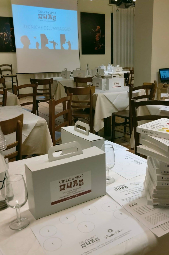 Sala del ristorante Cielo e Vino a Dairago allestito per un corso di degustazione vini. Sopra i tavoli si trovano le box e le info del corso